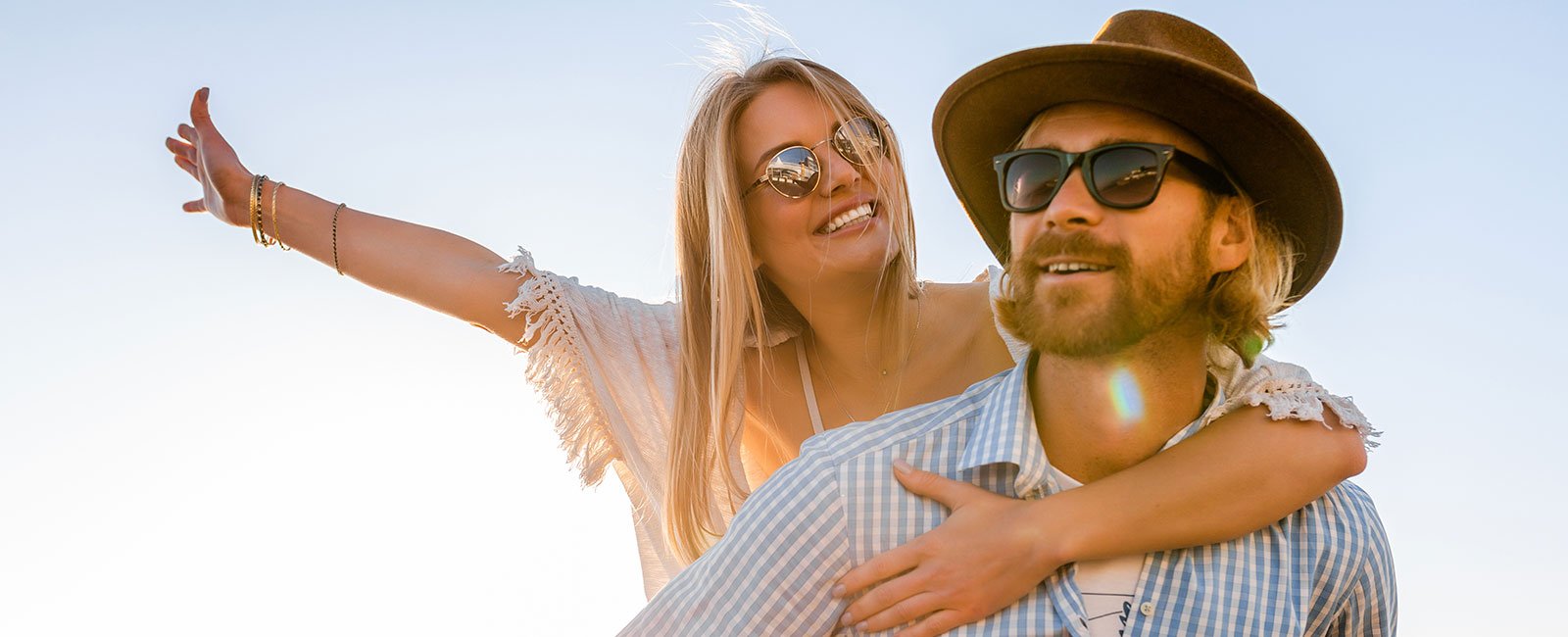 A joyful woman leans on a man outdoors