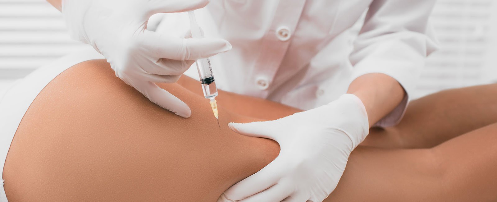 plastic-surgery-hawaii-hero-1 A healthcare professional gives a mesotherapy injection to a patient's thigh in a clinical setting.
