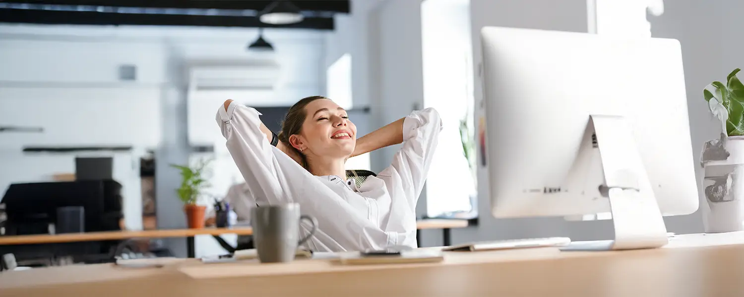 Woman in white shirt relaxes at desk
